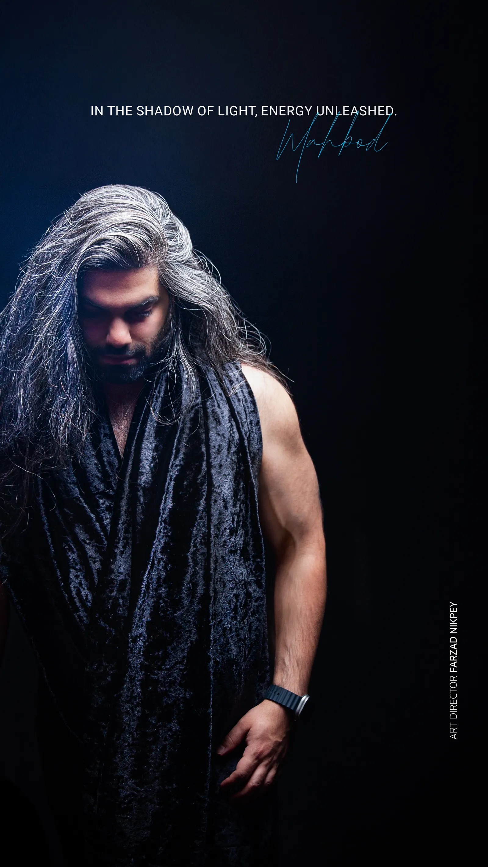 DJ Mahbod in a long scarf against a dark backdrop