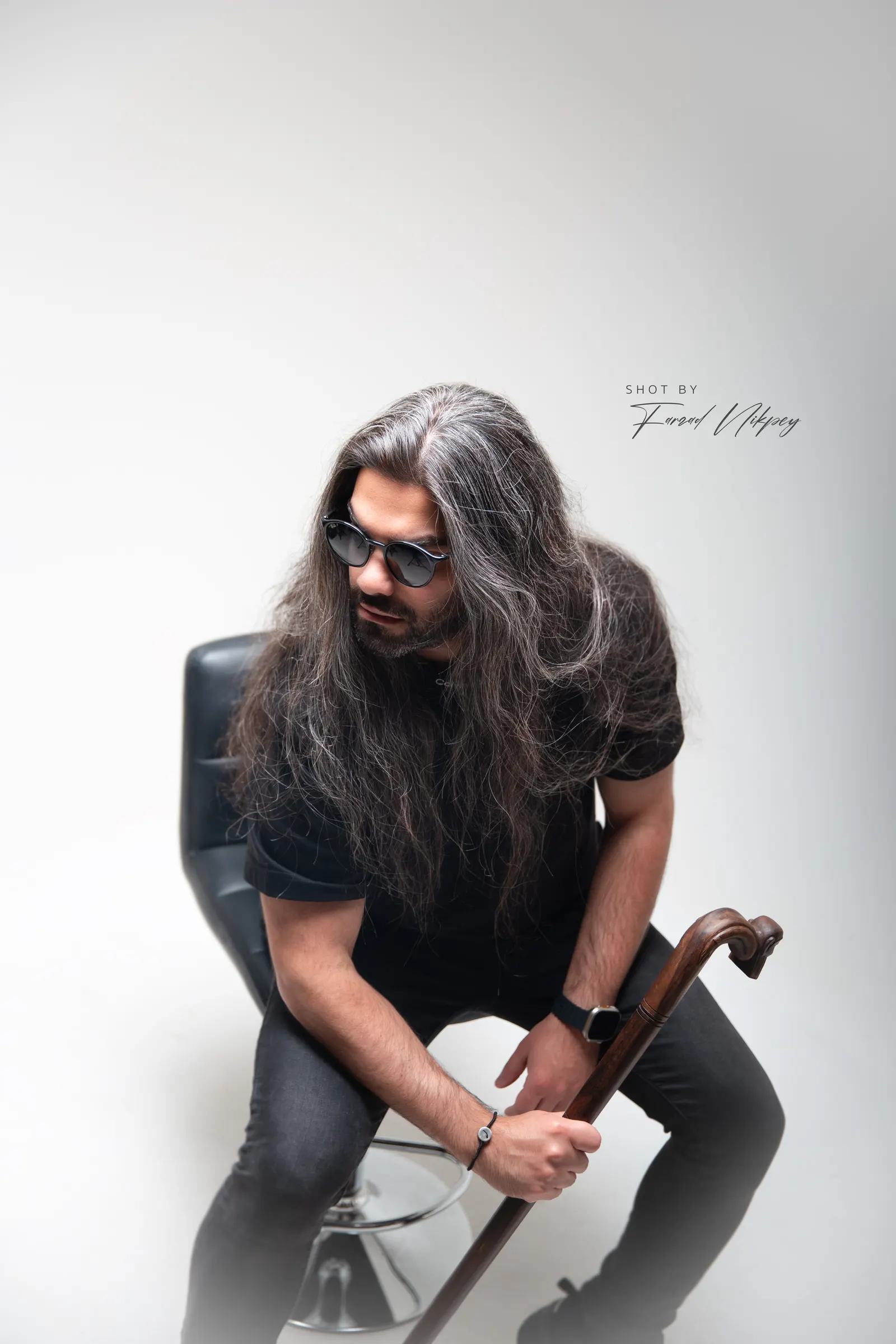 DJ Mahbod seated in the studio, long hair, black shirt